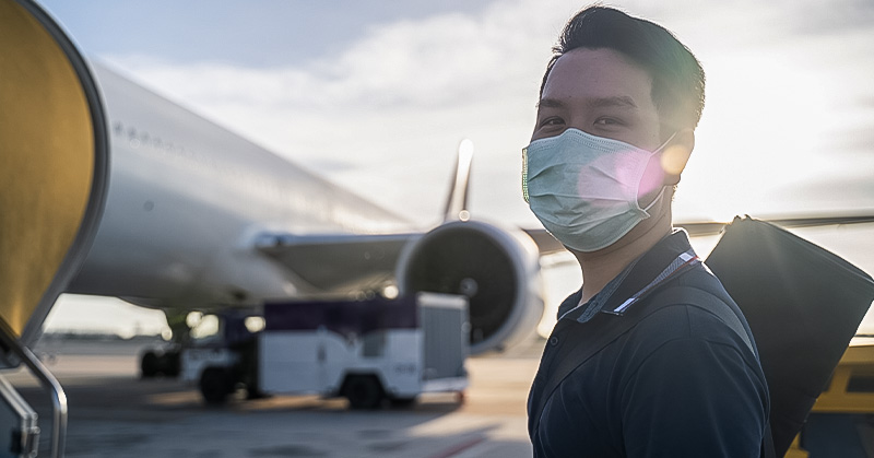 Joven con cubrebocas tomando un avión para estudiar en el extranjero